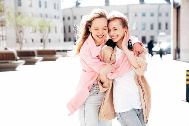 Duas jovens bonitas e sorridente em roupas de verão à moda ao ar livre