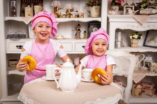 Duas jovens cozinheiras estão animadas com tortas cozidas, Jovens cozinheiras com tortas