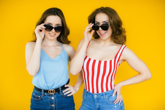 Duas jovens e lindas garotas hipster sorridentes e loiras em roupas de verão da moda Mulheres despreocupadas sensuais