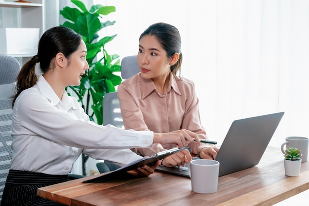 Duas jovens empresárias trabalham juntas no escritório.