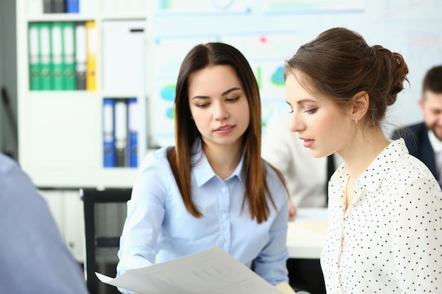 Duas jovens estudando documentos em um escritório