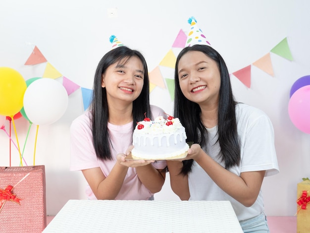 Foto duas jovens felizes desfrutam de bolo na festa de aniversário.