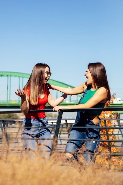 Duas jovens melhores amigas aguardando a ponte velha