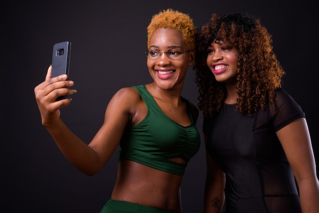 Duas jovens mulheres africanas juntas no preto