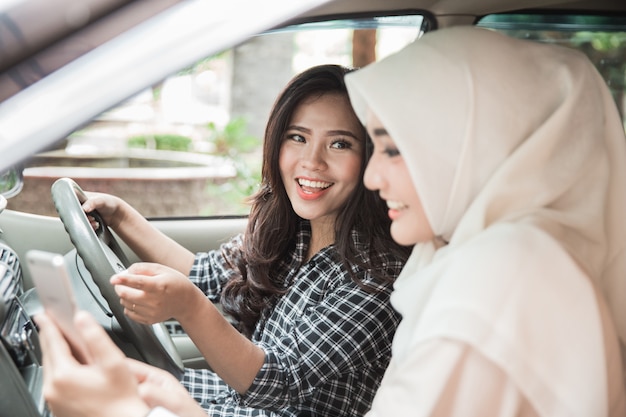 Duas jovens mulheres asiáticas no carro