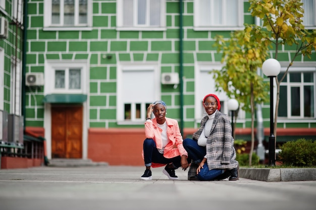 Duas jovens mulheres muçulmanas africanas, altas e magras, atraentes, modernas, em hijab ou lenço de cabeça de turbante e casaco