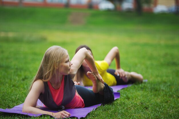 Duas jovens realizando treinamento de flexibilidade no parque, teleobjetiva