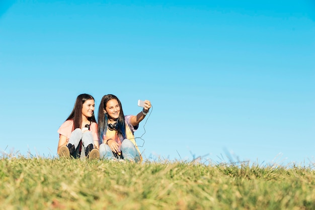 Duas lindas adolescentes tirando selfie no parque