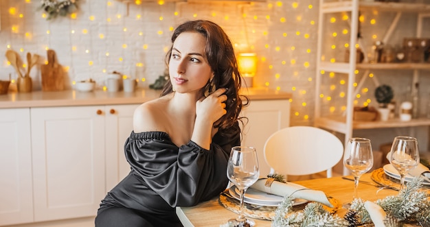 Duas lindas alegres jovens garotas felizes rindo da mesa de jantar de natal no fundo da cozinha de ano novo