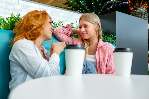 Duas lindas amigas sentam-se em um café após suas compras durante as vendas