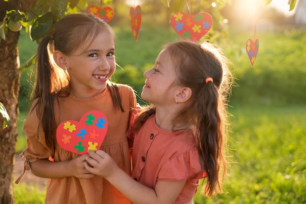 Duas lindas garotas engraçadas e felizes se apoiando no Dia da Conscientização do Autismo