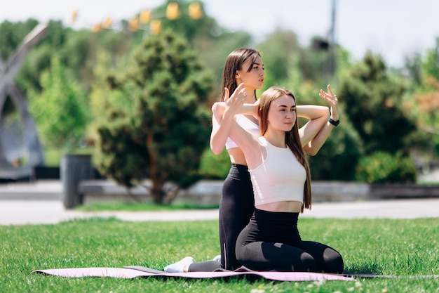 Foto duas lindas garotas fazem exercícios ao ar livre no parque
