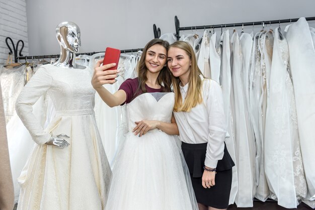 Duas lindas garotas fazendo selfie em salão de casamento