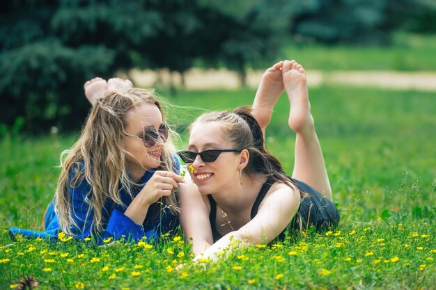 Duas lindas garotas se divertem em um prado verde no parque