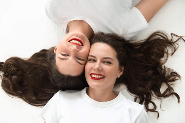Duas lindas irmãs gêmeas fecharam o retrato de rosto deitado no chão