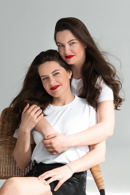 Duas lindas irmãs gêmeas posando de fundo branco