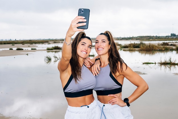 Duas lindas irmãs gêmeas usando smartphone