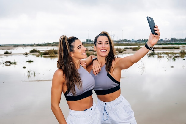 Duas lindas irmãs gêmeas usando smartphone