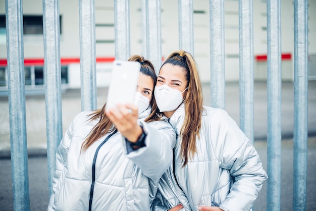 Duas lindas irmãs gêmeas usando smartphone