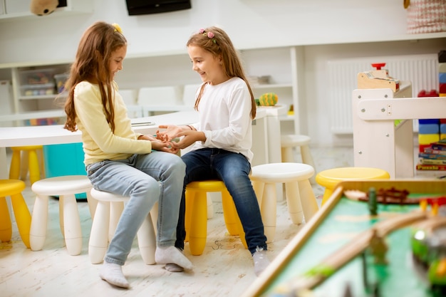 Duas lindas melhores amigas juntas na sala de jogos do berçário