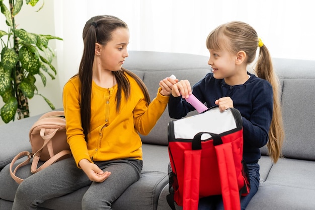 Duas lindas meninas da escola com mochilas.