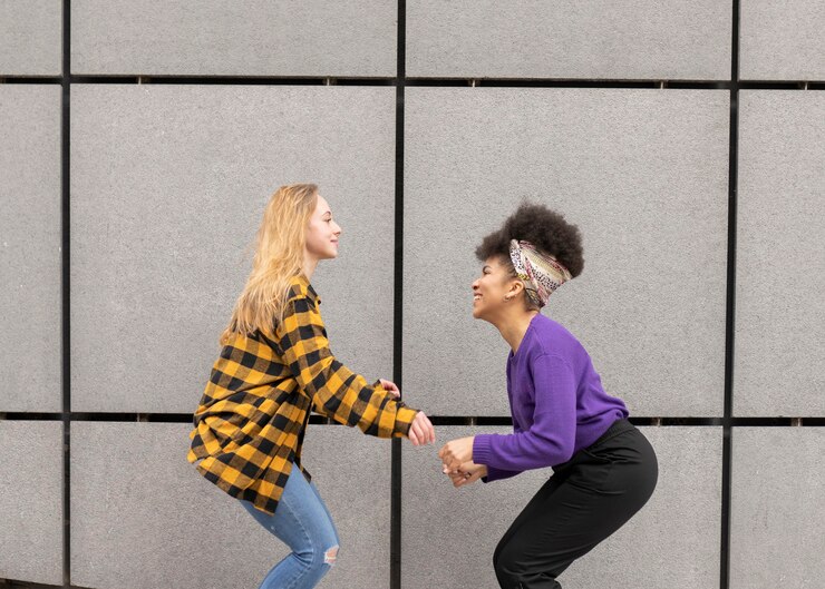 Foto duas lindas mulheres africanas e brancas pulando na cidade