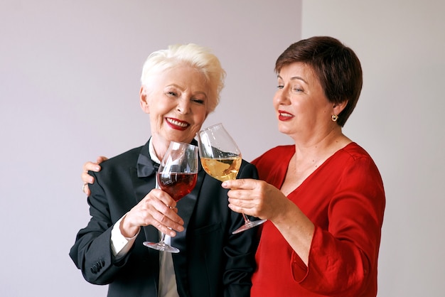 Duas lindas mulheres maduras e elegantes bebendo vinho
