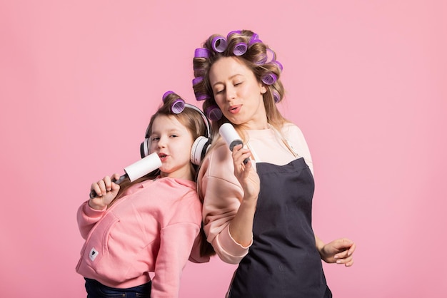 Duas lindas mulheres, mãe e filha, cantam suas músicas favoritas em um microfone de mentira