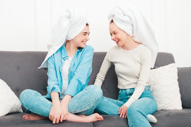 Duas lindas mulheres sorridentes sentadas no sofá