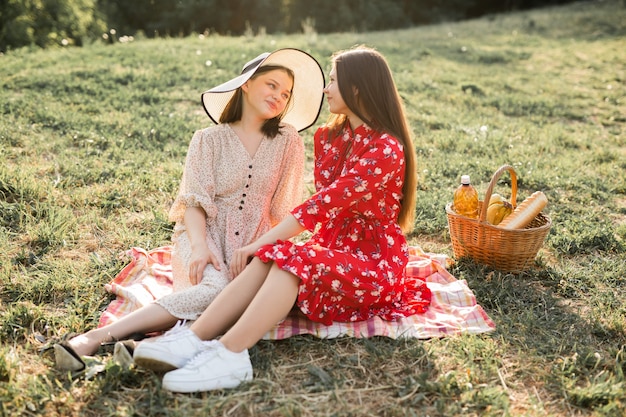 duas lindas namoradas jovens no parque de verão na grama