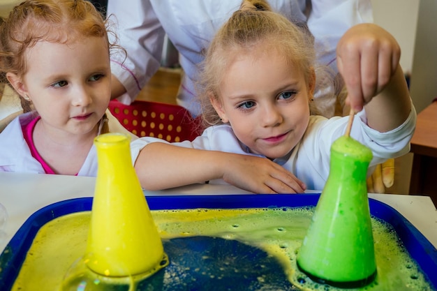 duas loiras químico escola garoto estudante garotinhas (irmãs namoradas) experimento químico vestido médico branco sala de aula ciência