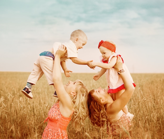 Duas mães com filhos no campo