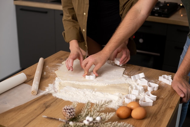 Duas mãos cozinhando biscoitos na cozinha