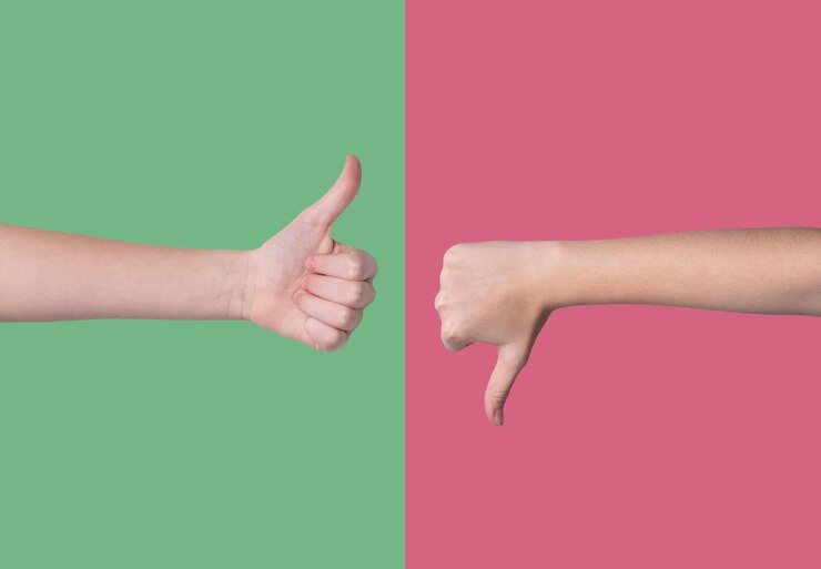 Foto duas mãos mostrando dedos para cima e dedos para baixo gestos em um fundo vermelho e verde
