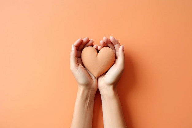 Foto duas mãos sobre uma laranja deitada segurando um coração