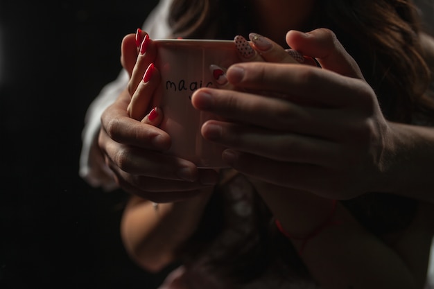 Duas mãos uma caneca de café quente.