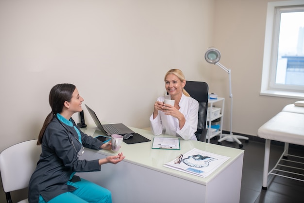 Duas médicas conversando após o turno na clínica