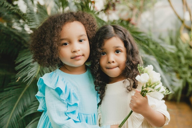 Duas meninas alegres no jardim botânico primavera verão