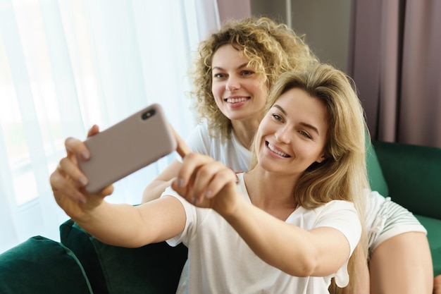 Duas meninas alegres tirando uma selfie juntas em casa