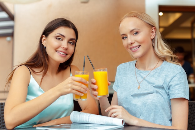 Duas meninas bonitas, sentado junto à mesa no café