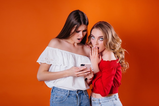 Foto duas meninas bonitas tirando uma selfie e olhando o telefone