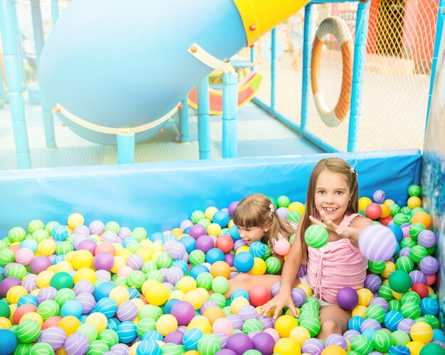 Foto duas meninas brincando na piscina com bolas de plástico