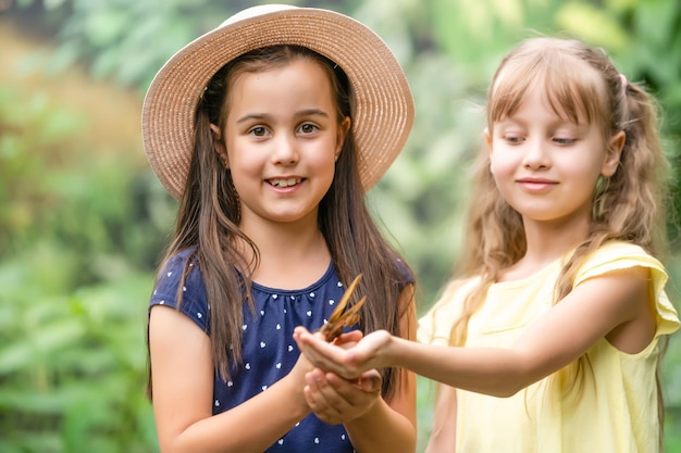 duas meninas com borboletas em uma estufa