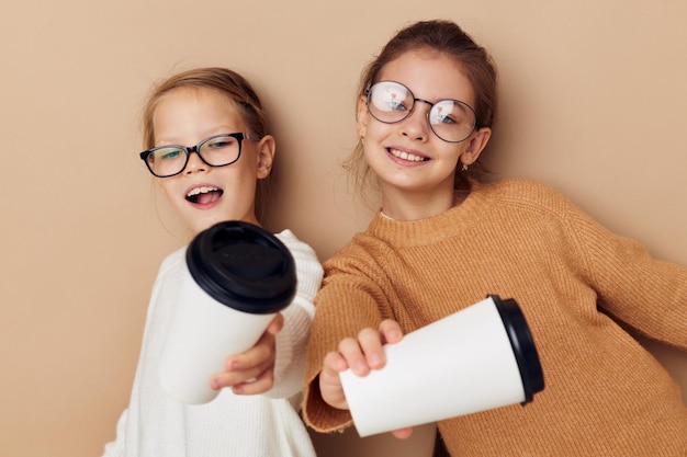 Duas meninas com copos descartáveis nas mãos