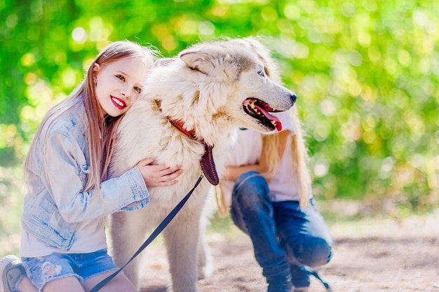 Duas meninas com um cachorro no parque Big dog