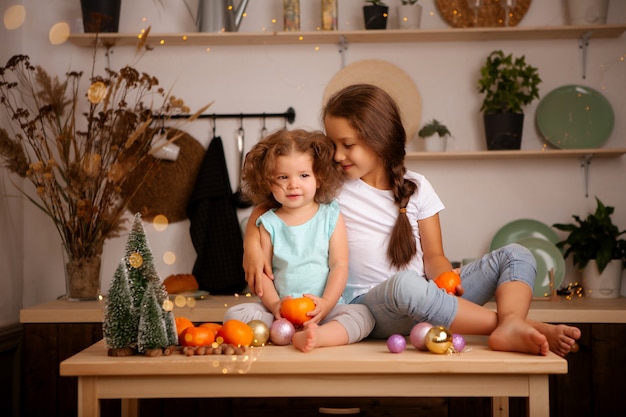 duas meninas comendo tangerinas na cozinha de Natal