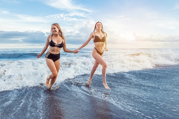 Duas meninas correm do oceano