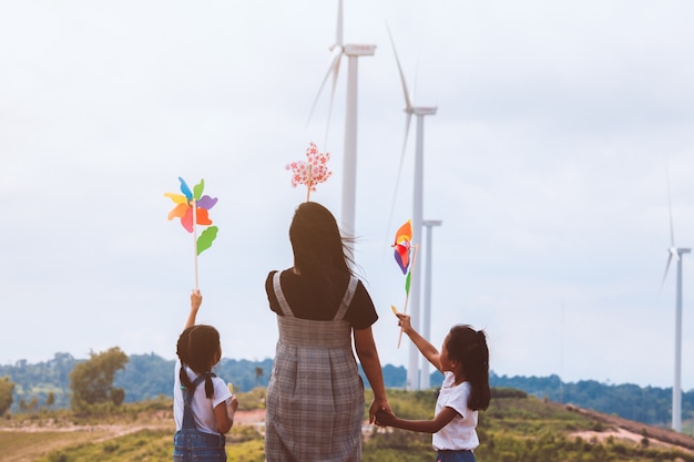 Duas meninas criança asiática e sua mãe brincando com brinquedo de turbina de vento juntamente com diversão