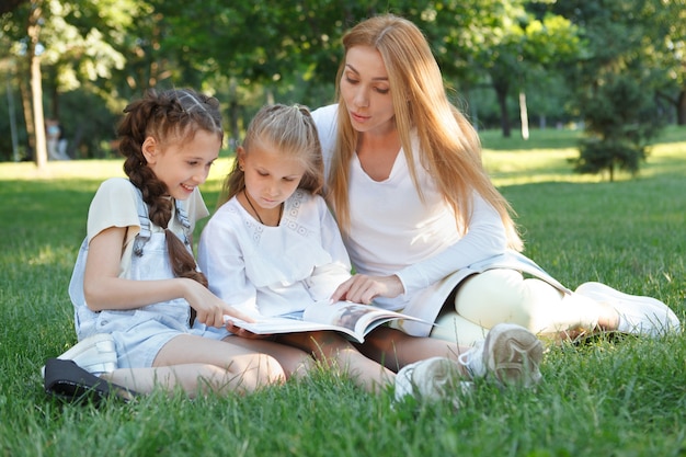 Duas meninas em aula ao ar livre no parque com sua professora favorita