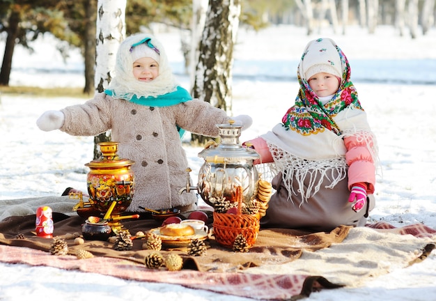 Duas meninas em casacos e xales em estilo russo no seu